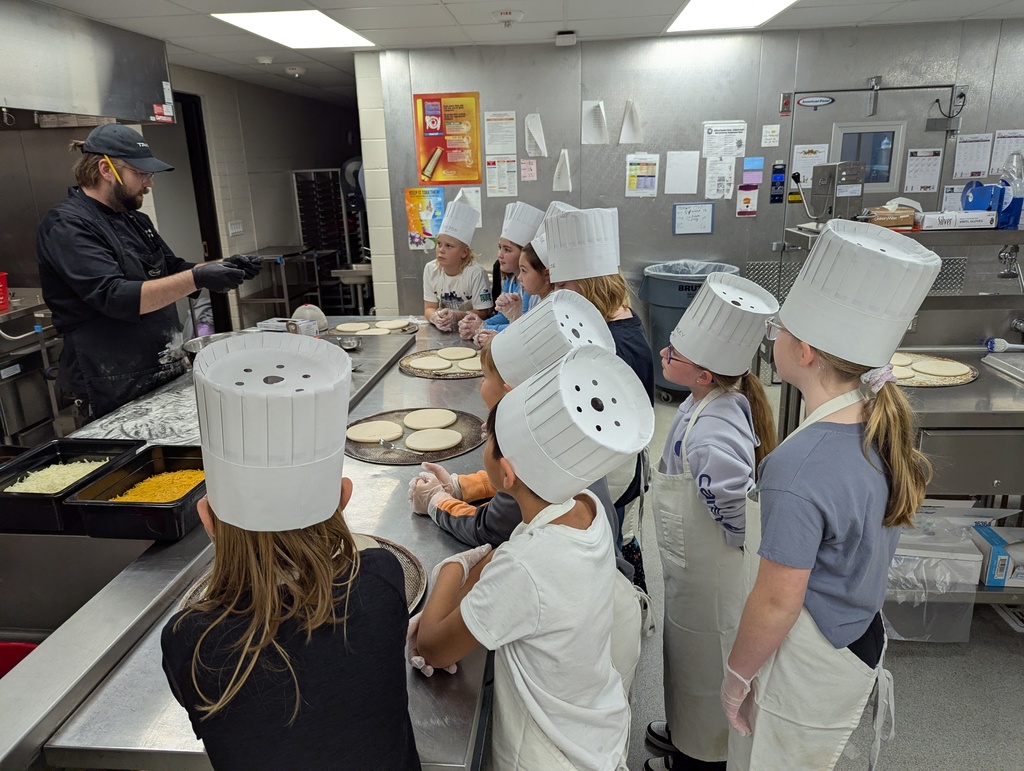 Students watching chef Ben create pizza dough.