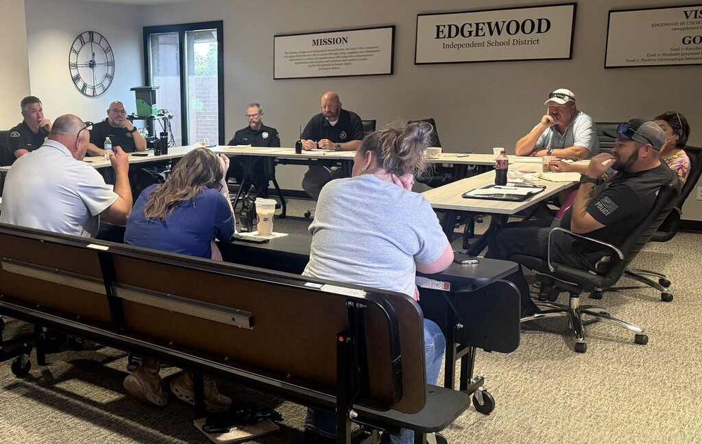 Edgewood ISD administrators, safety personnel, and city and county law enforcement officials sit together around tables during a district safety and security meeting. The group is gathered in an Edgewood ISD conference room for discussion and collaboration focused on school safety.