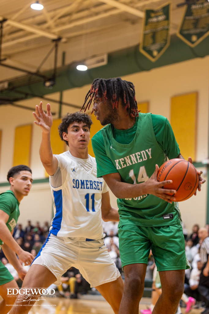 kennedy basketball player goes up against another athlete