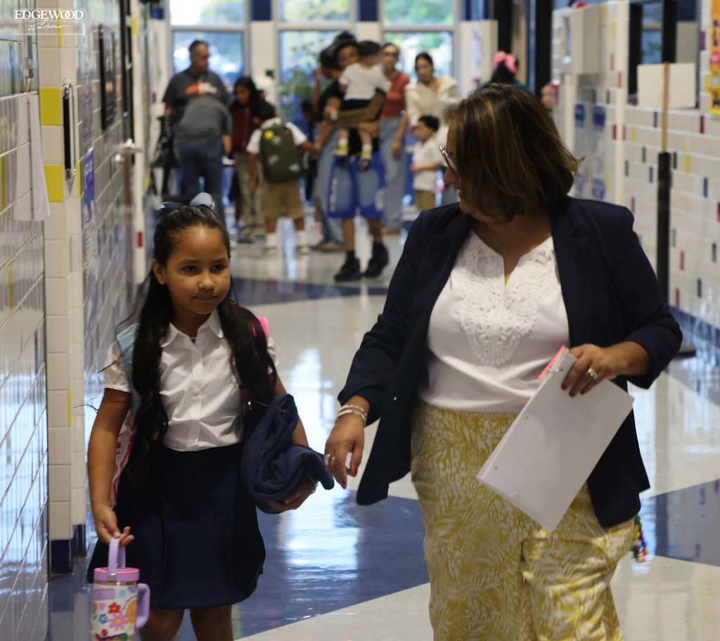 Principal Esquivel helps a student find her classroom on the first day of school