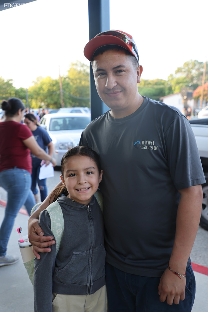 A student gets a big hug from her dad before going into RDLA for the first day of school