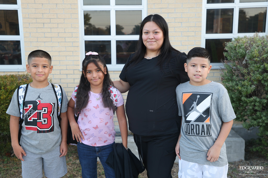Three siblings pose with their mom for a first day photo before going into RDLA