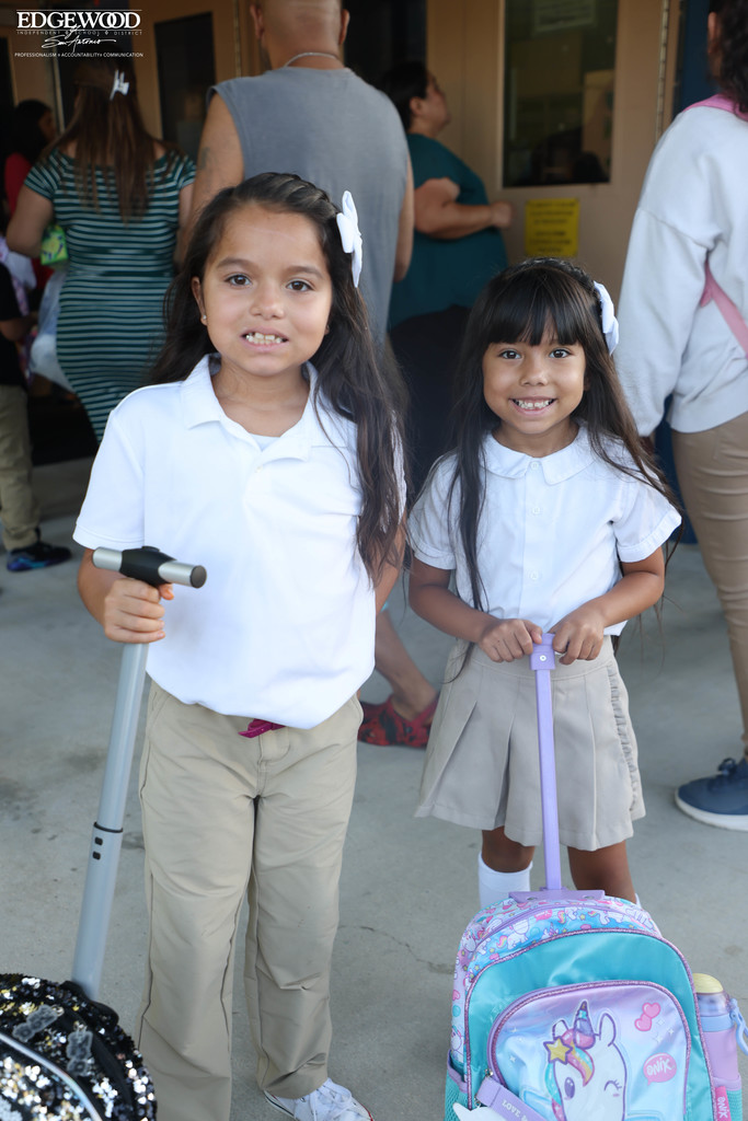 two sisters show off their new backpacks before heading into class at RDLA
