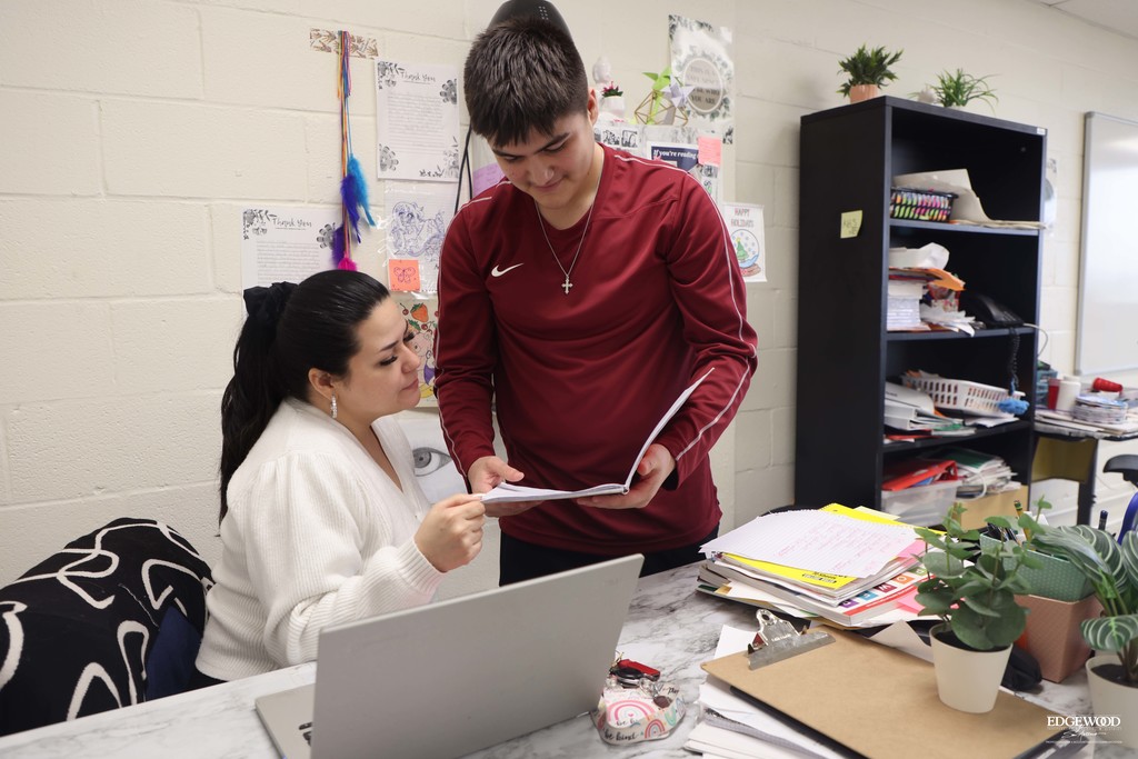JFK Teacher with a student reviewing homework