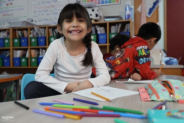 Student working on classwork with a smile