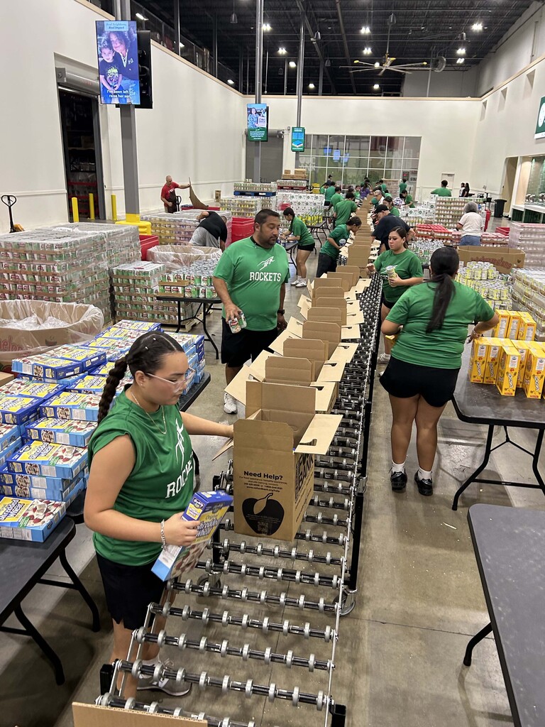 JFK Athletes and coaches sorting boxes of food at the Food Bank