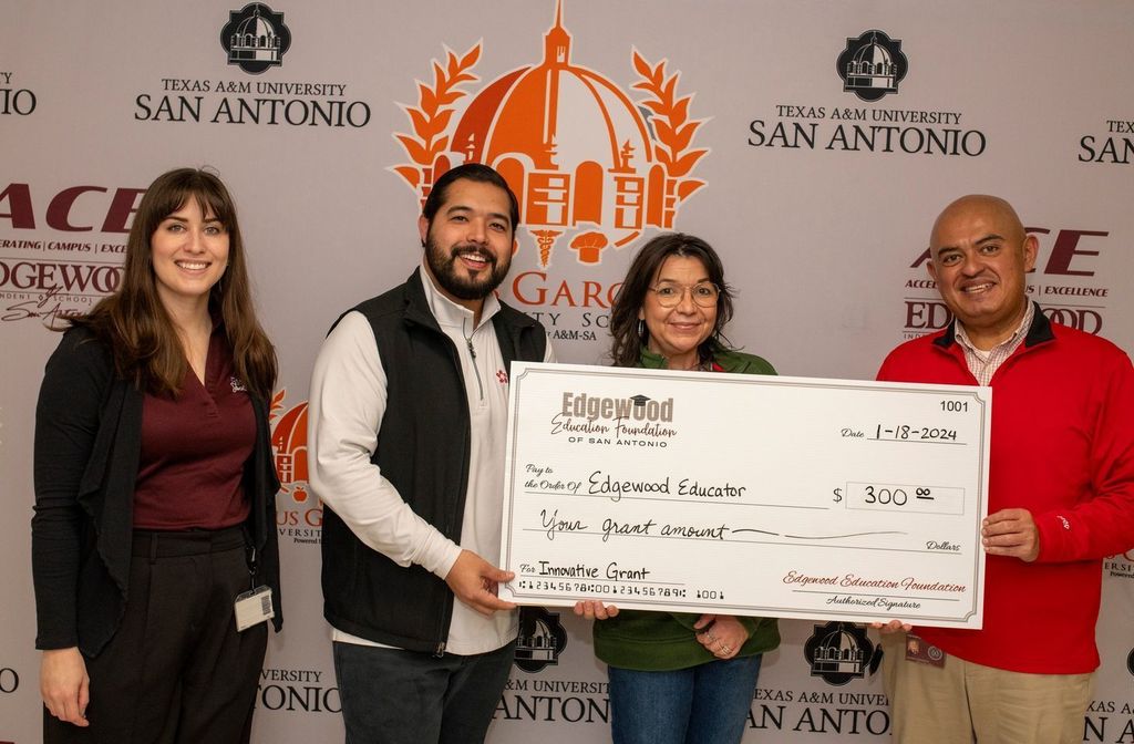 teachers smiling and holding a giant check