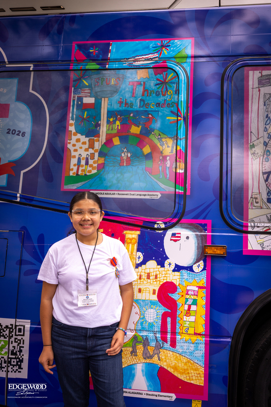 Mia by the Fiesta bus that features her artwork