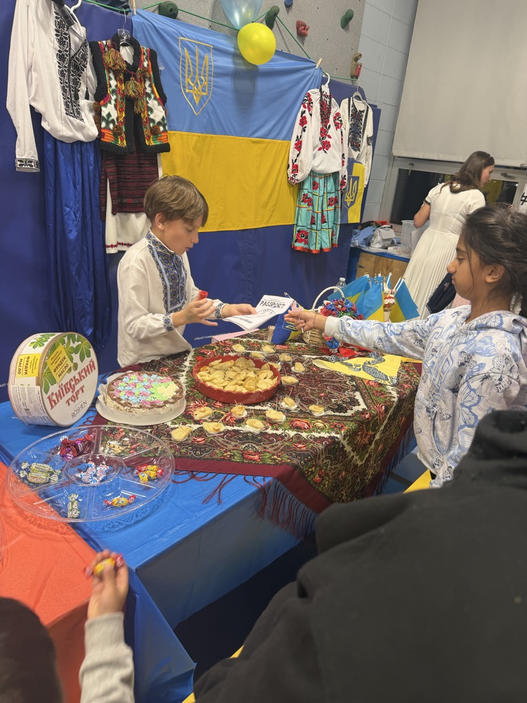 student presenting another student with a stamp for visiting his table