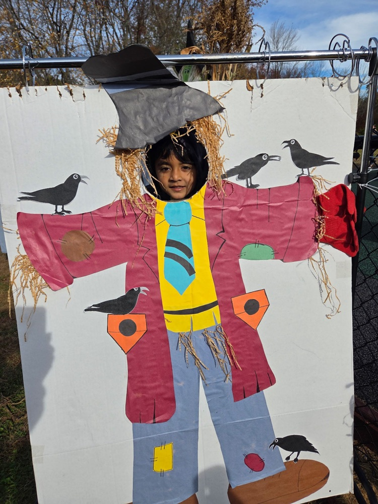 One young child with his face in a scarecrow cut out
