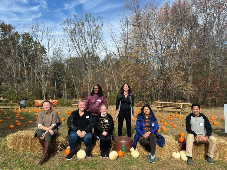 adult parent volunteers sitting on a hay bale