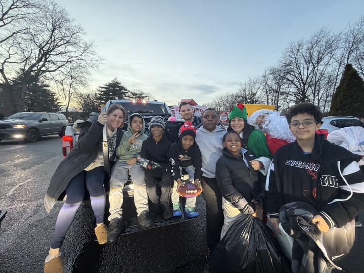 Santa, Jingles and Benny delivering presents with Dr. Bevere and Mr. D