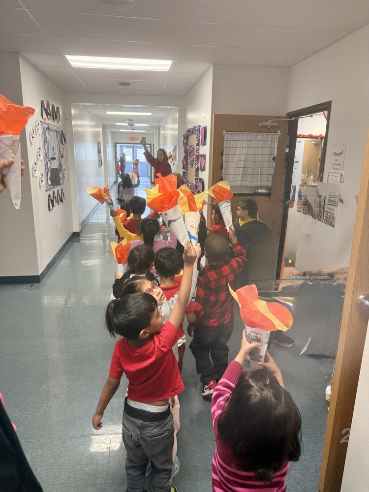 preschool children holding up a handmade paper torch