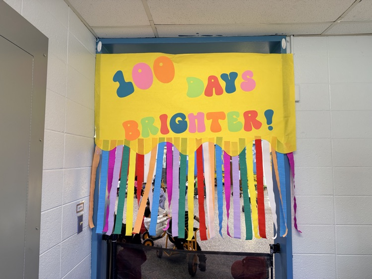 100 days brighter banner with colorful streamers under it 
