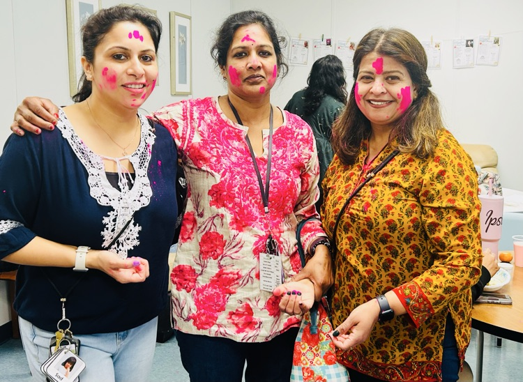 women dressed in traditional Indian clothes with colors on their faces 
