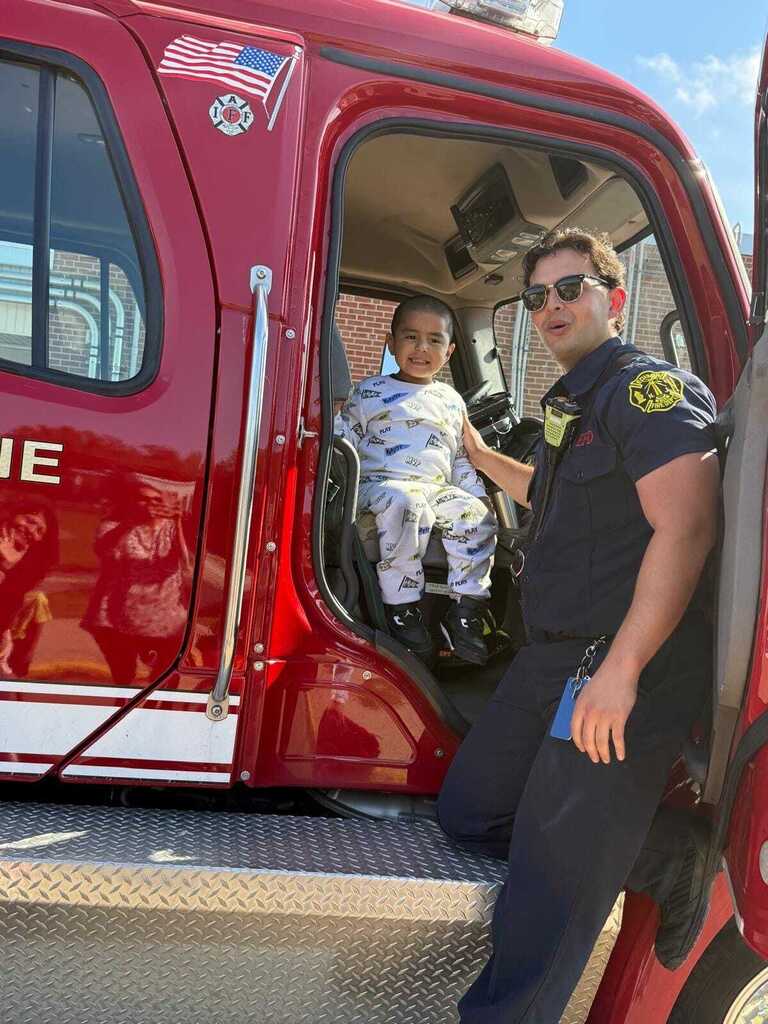 Little boy sitting in a fire truck