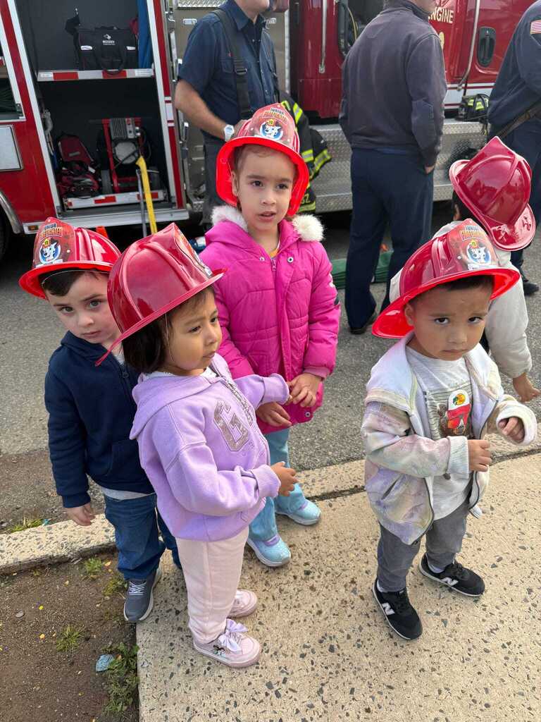Preschoolers wearing red fire helmets