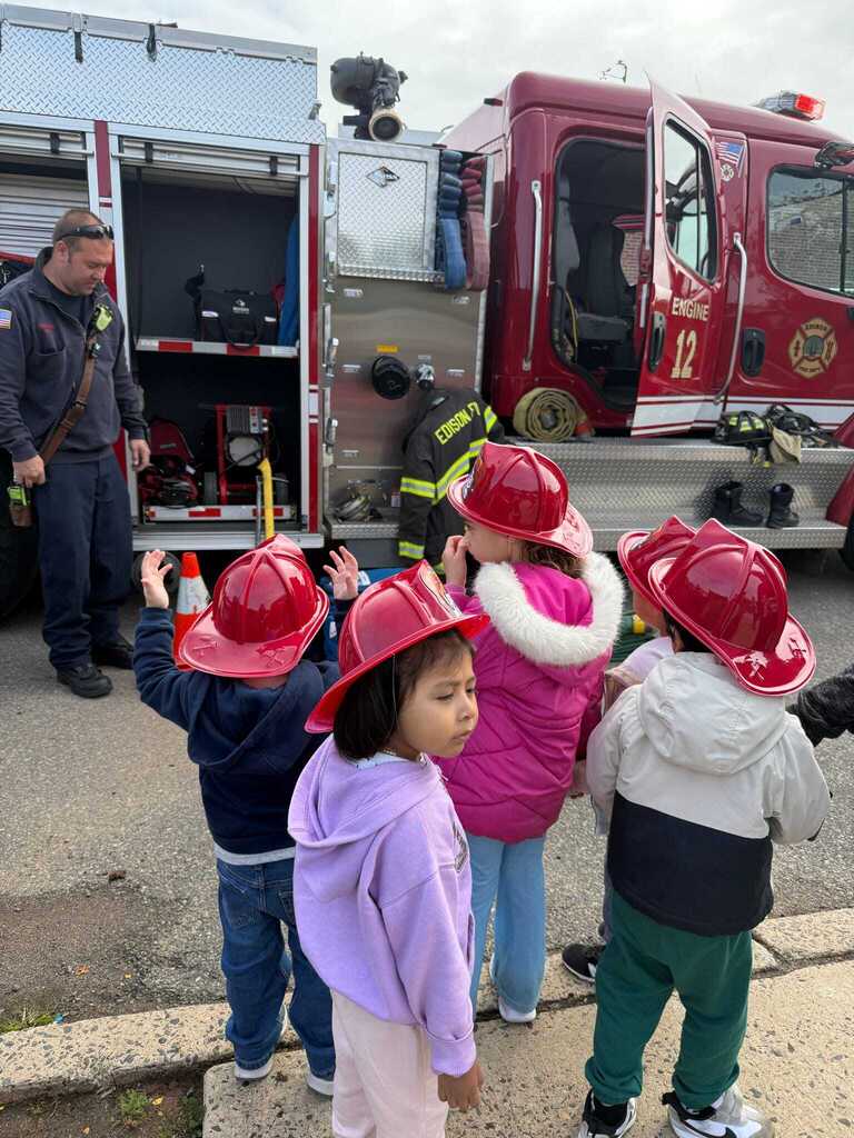 Preschoolers looking at a red fire truck