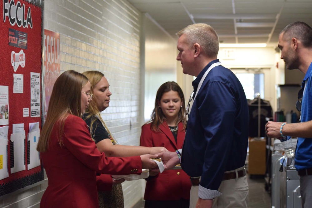 FCCLA Students & Sponsor hand out cookies to guest administrators