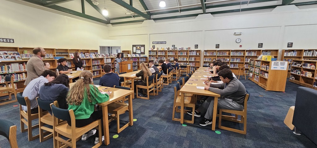 Students sitting at long tables in a library