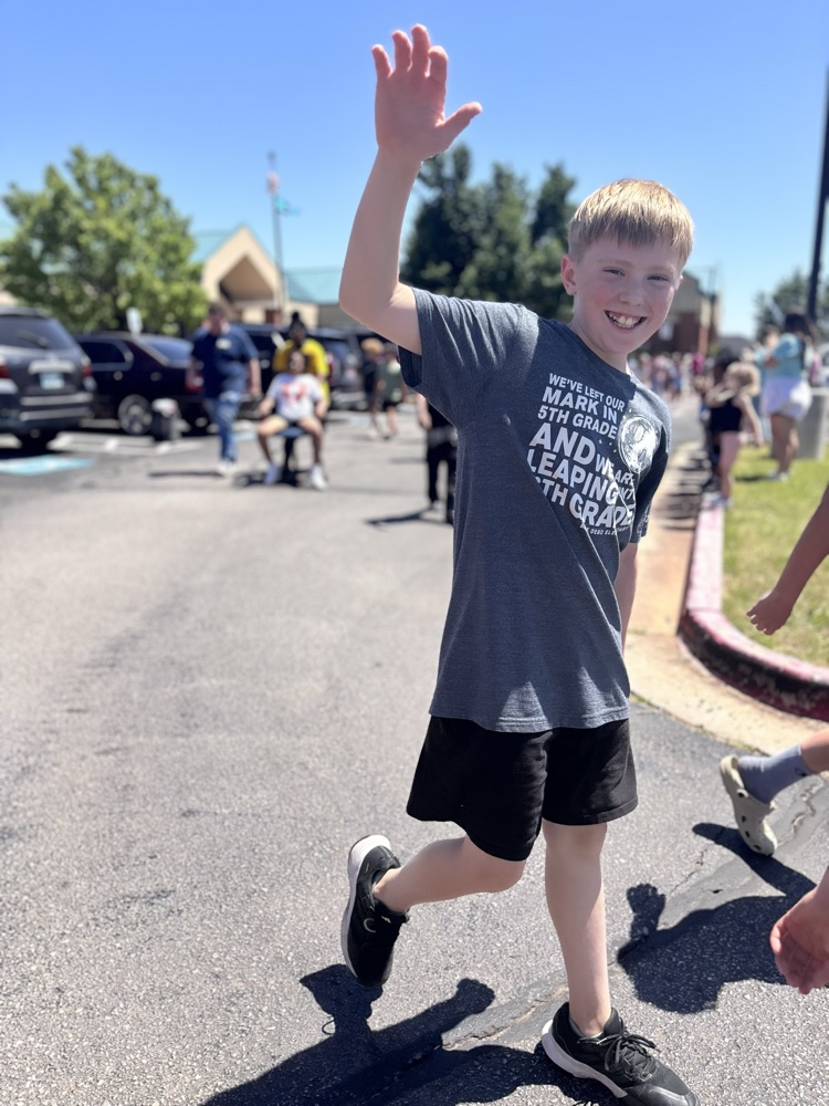 fifth grader waving during graduation clap out 
