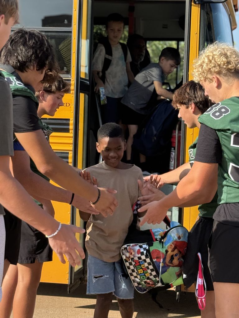 Students welcomed to the building by football players