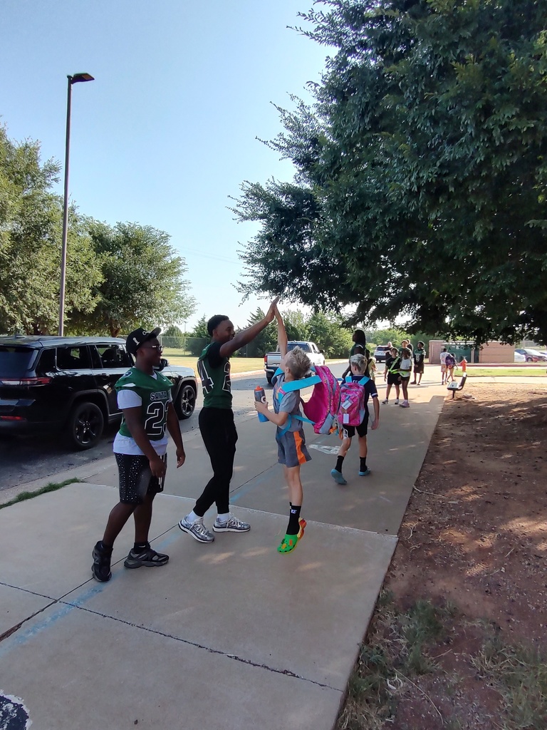 Students welcomed to the building by football players