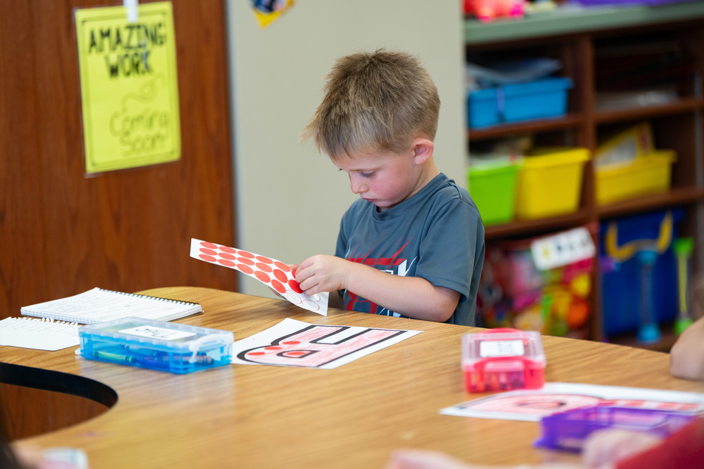 pre schooler working on a craft at their table