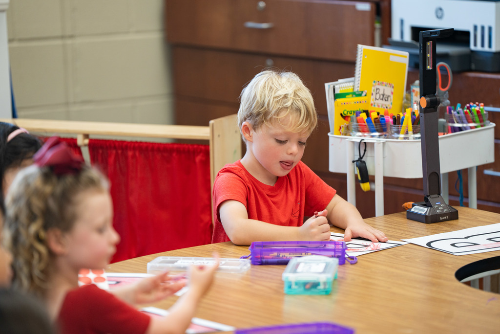 pre schooler working on a craft at their table