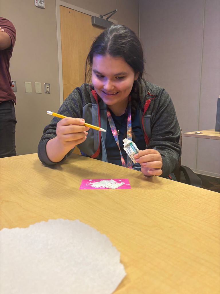 intern spreading toothpaste on paper