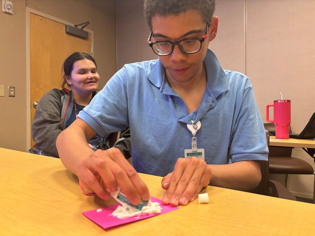 intern spreading toothpaste on paper