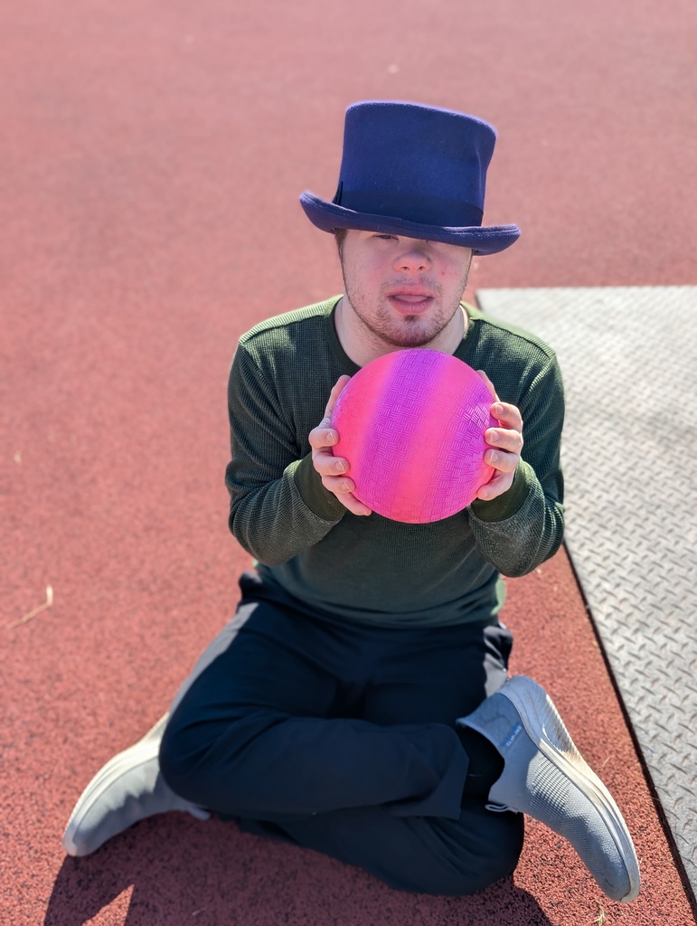 intern wearing a hat and holding a pink ball