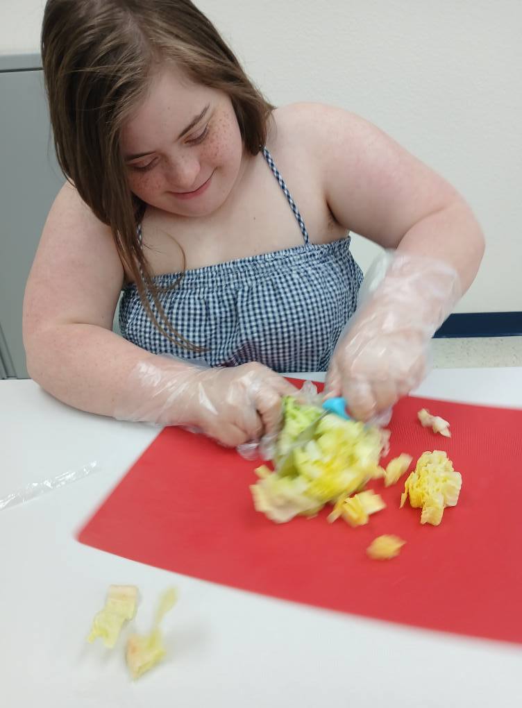 an intern cutting lettuce