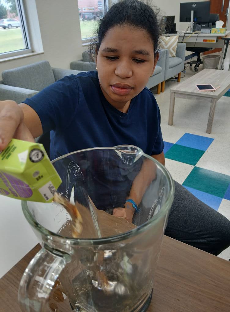 an intern pouring juice in a blender