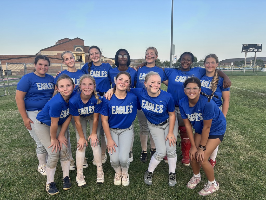 Lady Eagles softball team is pictured standing together on the Summit softball field after winning their game against Heartland.
