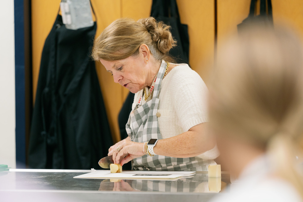 students cutting up a potato during class