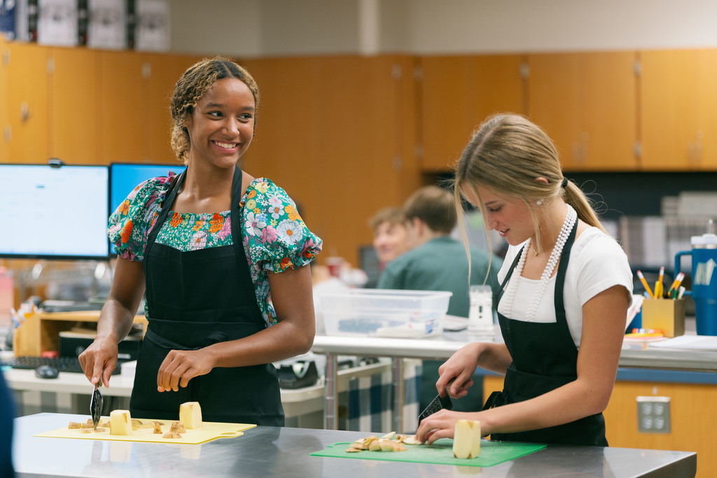 students cutting up a potato during class