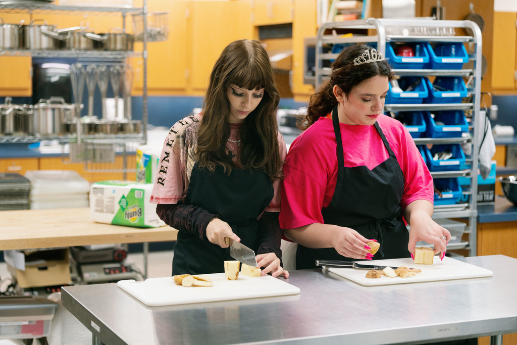 students cutting up a potato during class