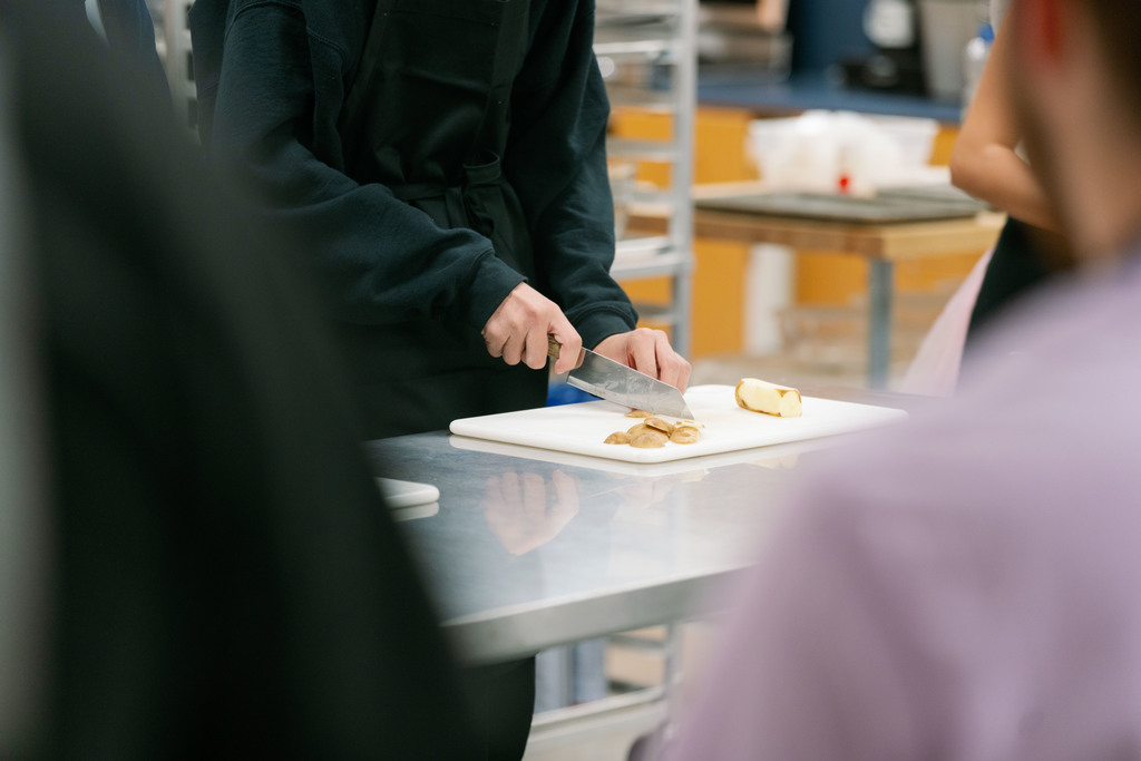 students cutting up a potato during class