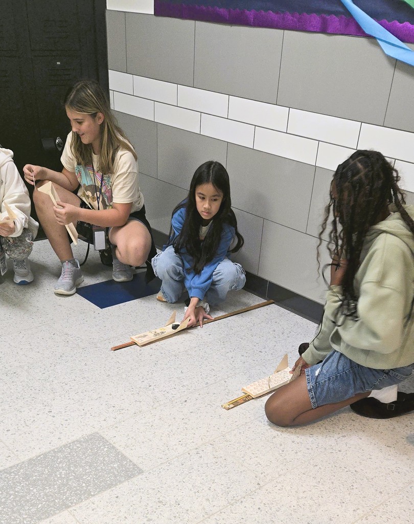 Group of students in the hallway testing their skimmers in engineering class.