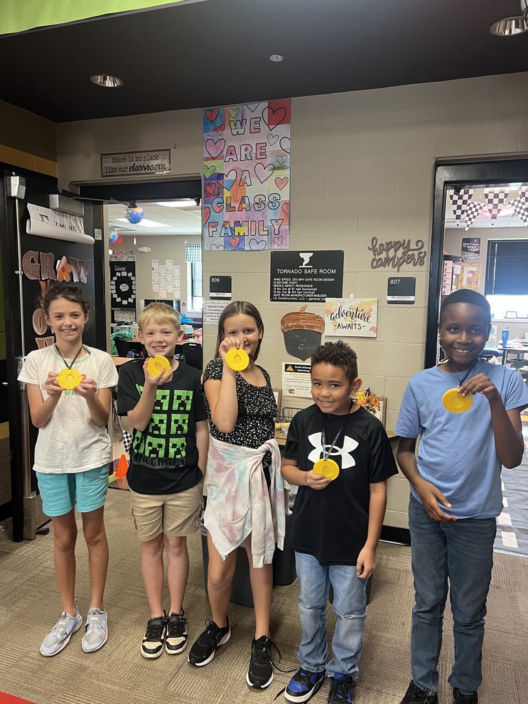 3 boys and 2 girls showing their egg crash day medals