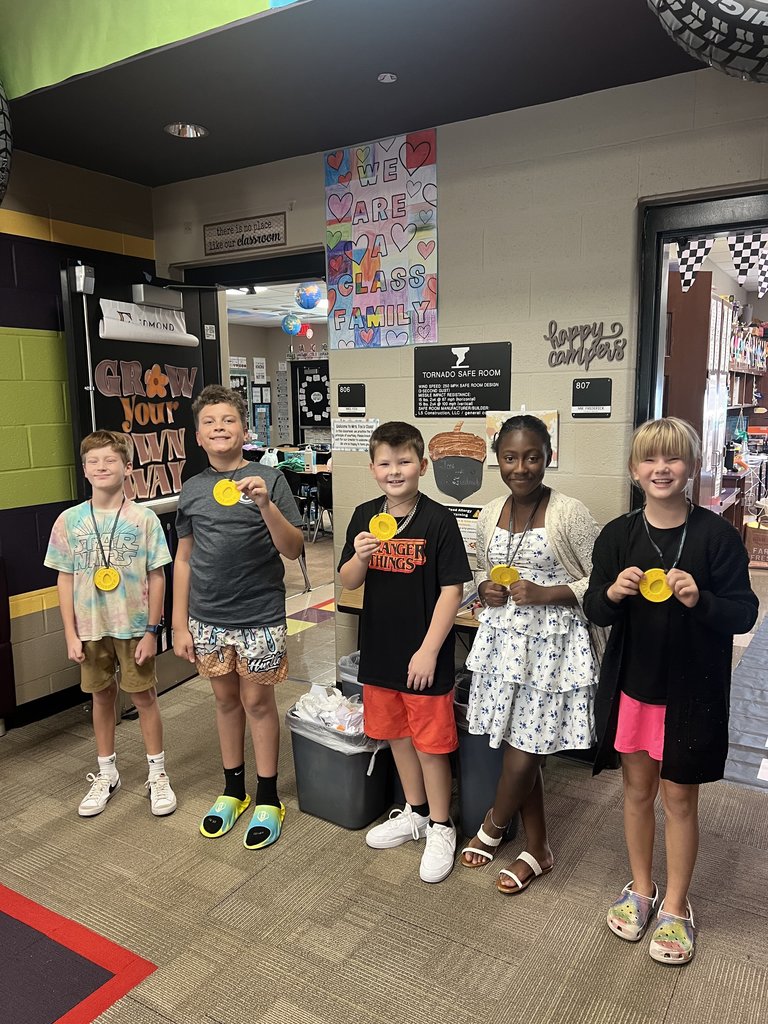 3 boys and 2 girls showing their egg crash day medals