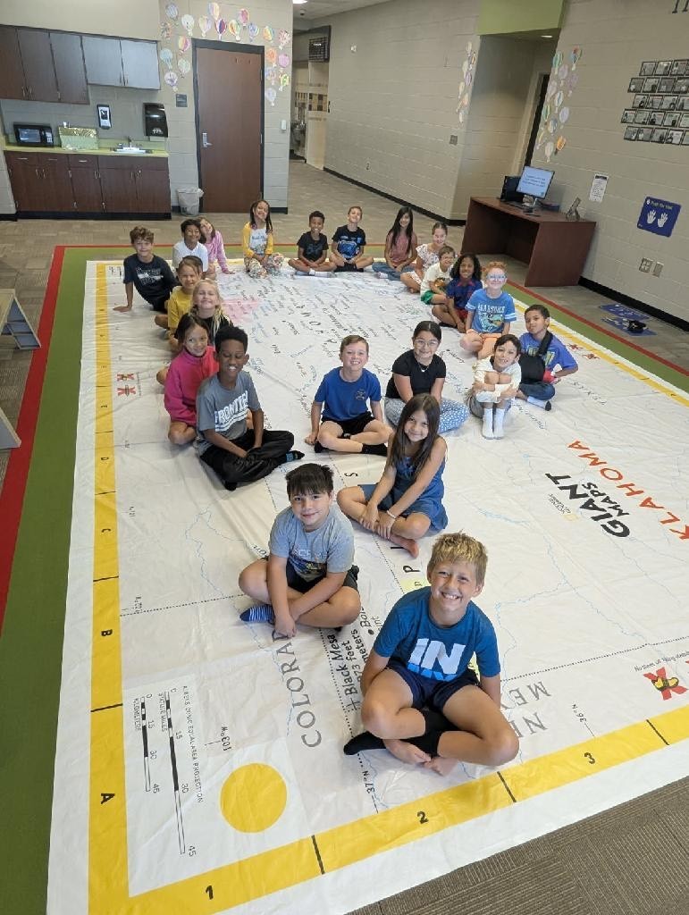 Students walking on and learning about a giant map of Oklahoma