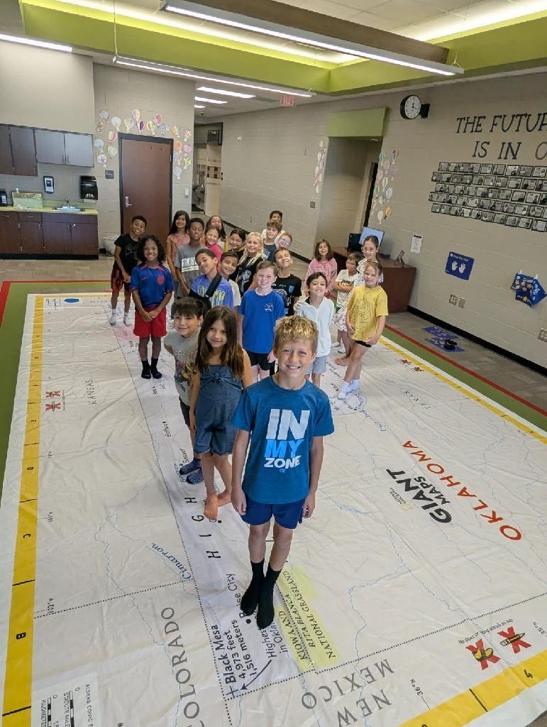 Students walking on and learning about a giant map of Oklahoma