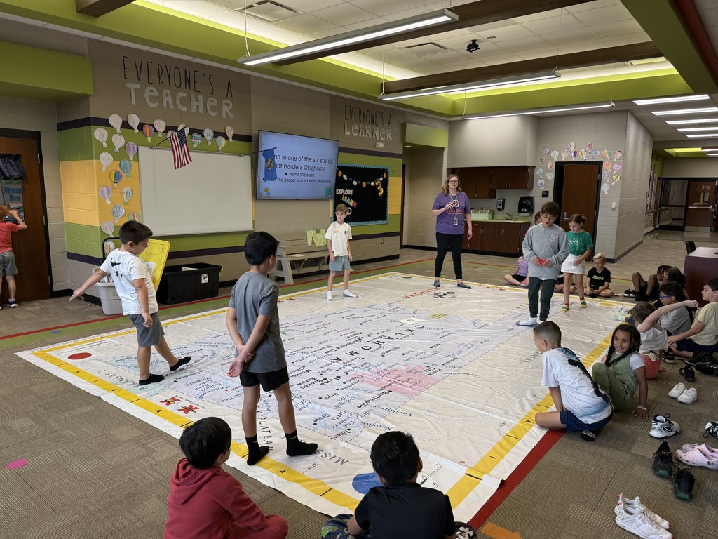 Students walking on and learning about a giant map of Oklahoma