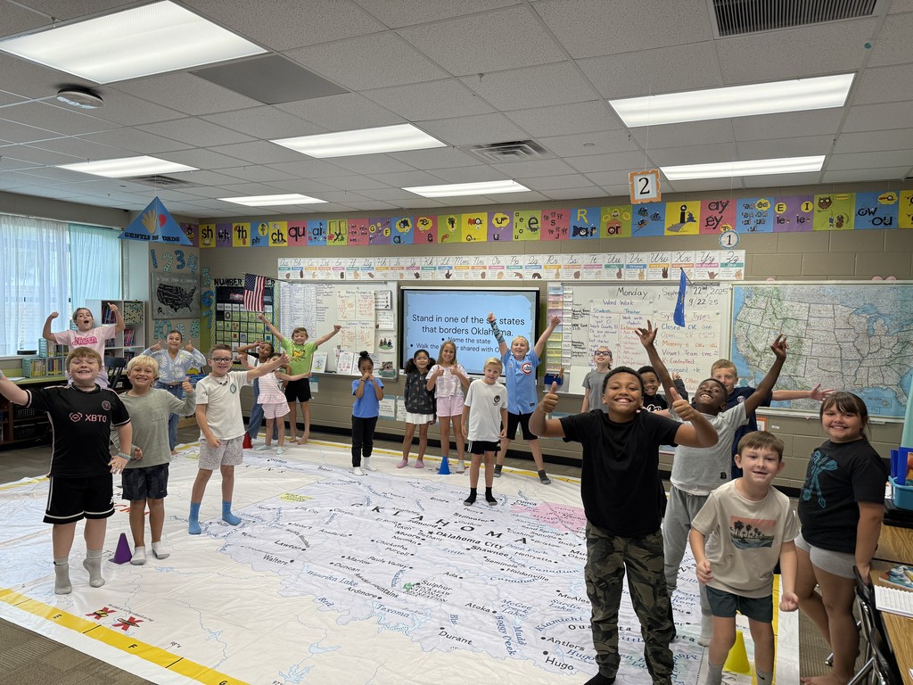 Students walking on and learning about a giant map of Oklahoma
