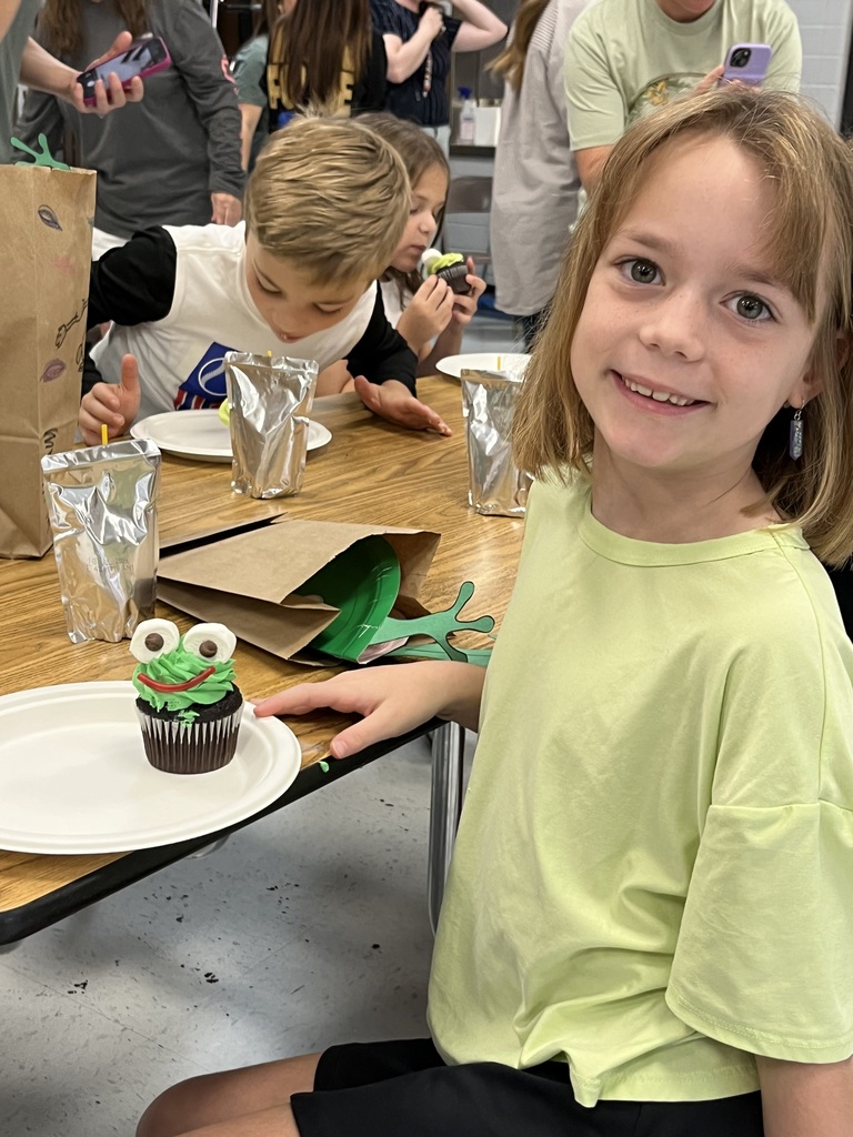 Second grader poses with frog cupcake