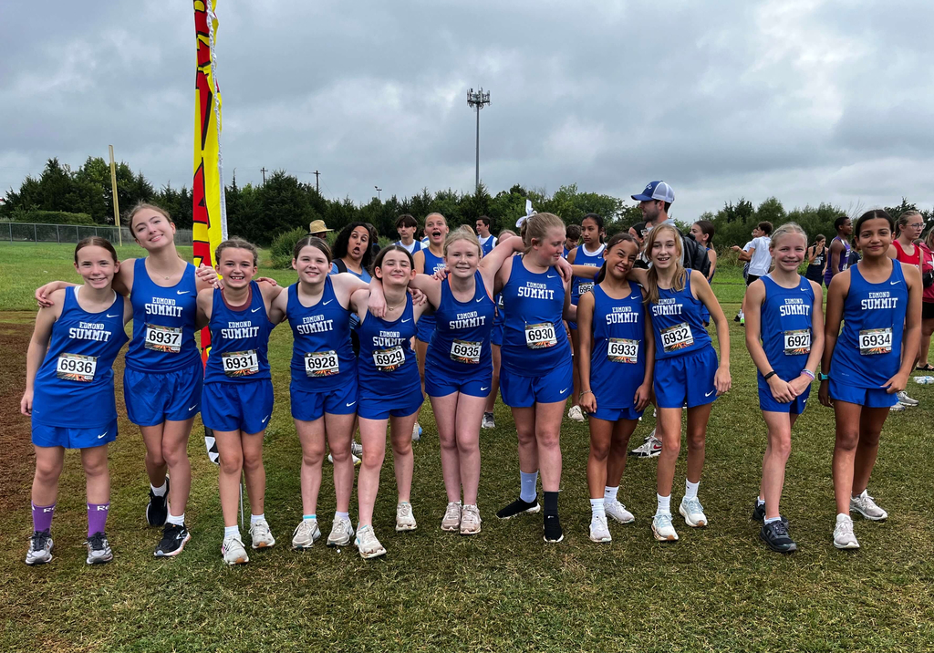 7th grade girls cross country athletes pictured standing together and smiling.