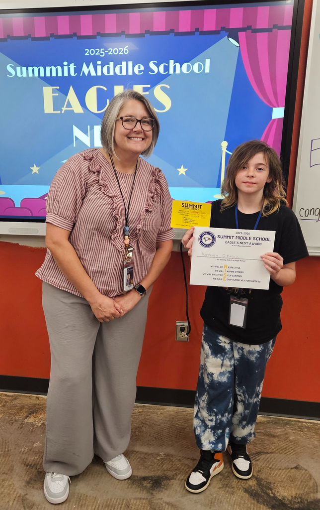 Mrs. Jacobs stands next to the student she nominated for Eagle's Nest.