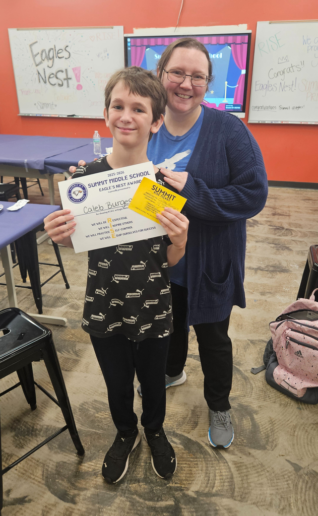 Mrs. Andrews stands next to the student she nominated for Eagle's Nest.